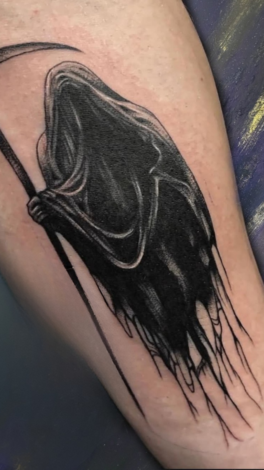 Black and grey grim reaper tattoo on forearm