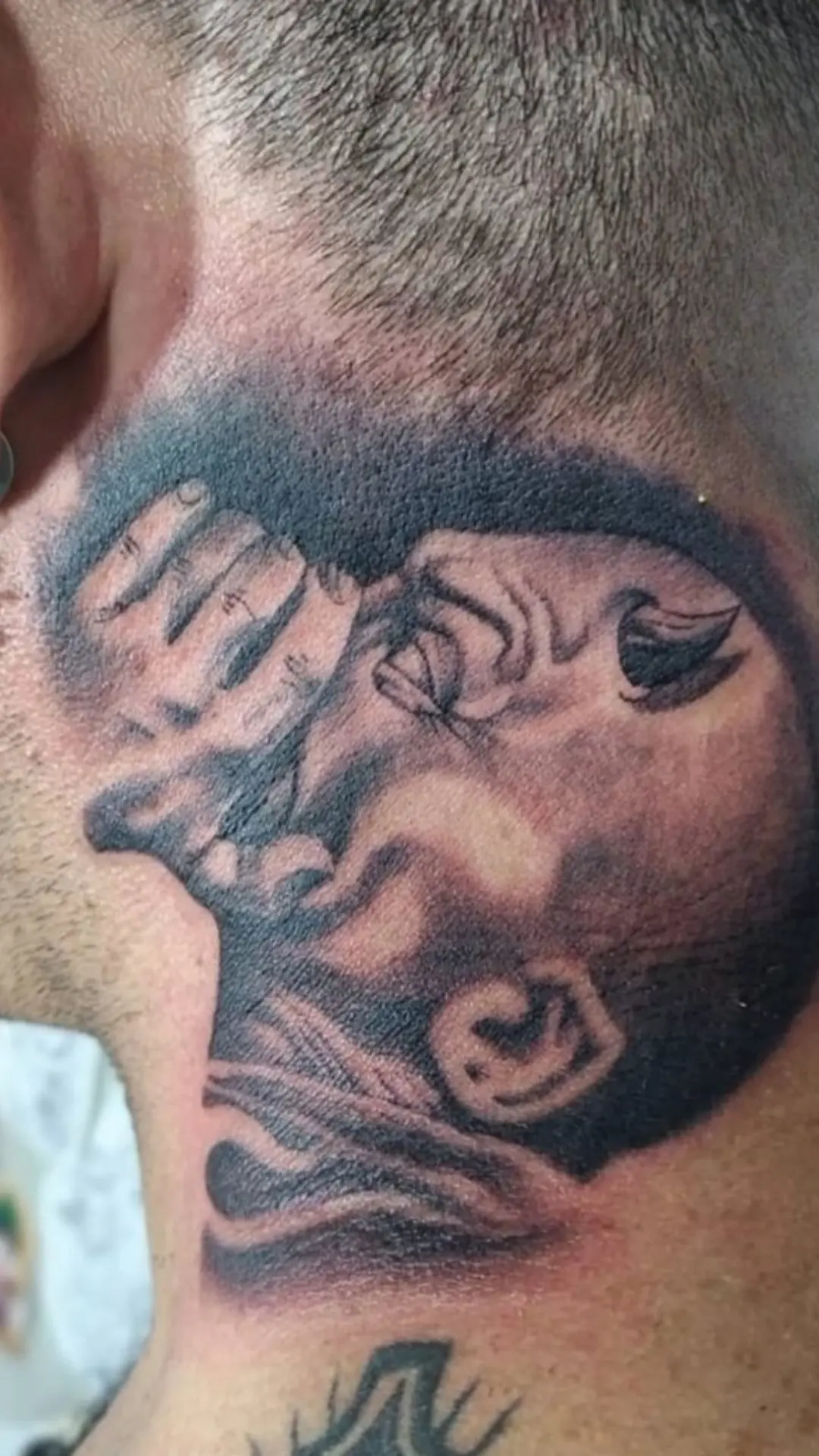 Black and grey portrait tattoo on the neck