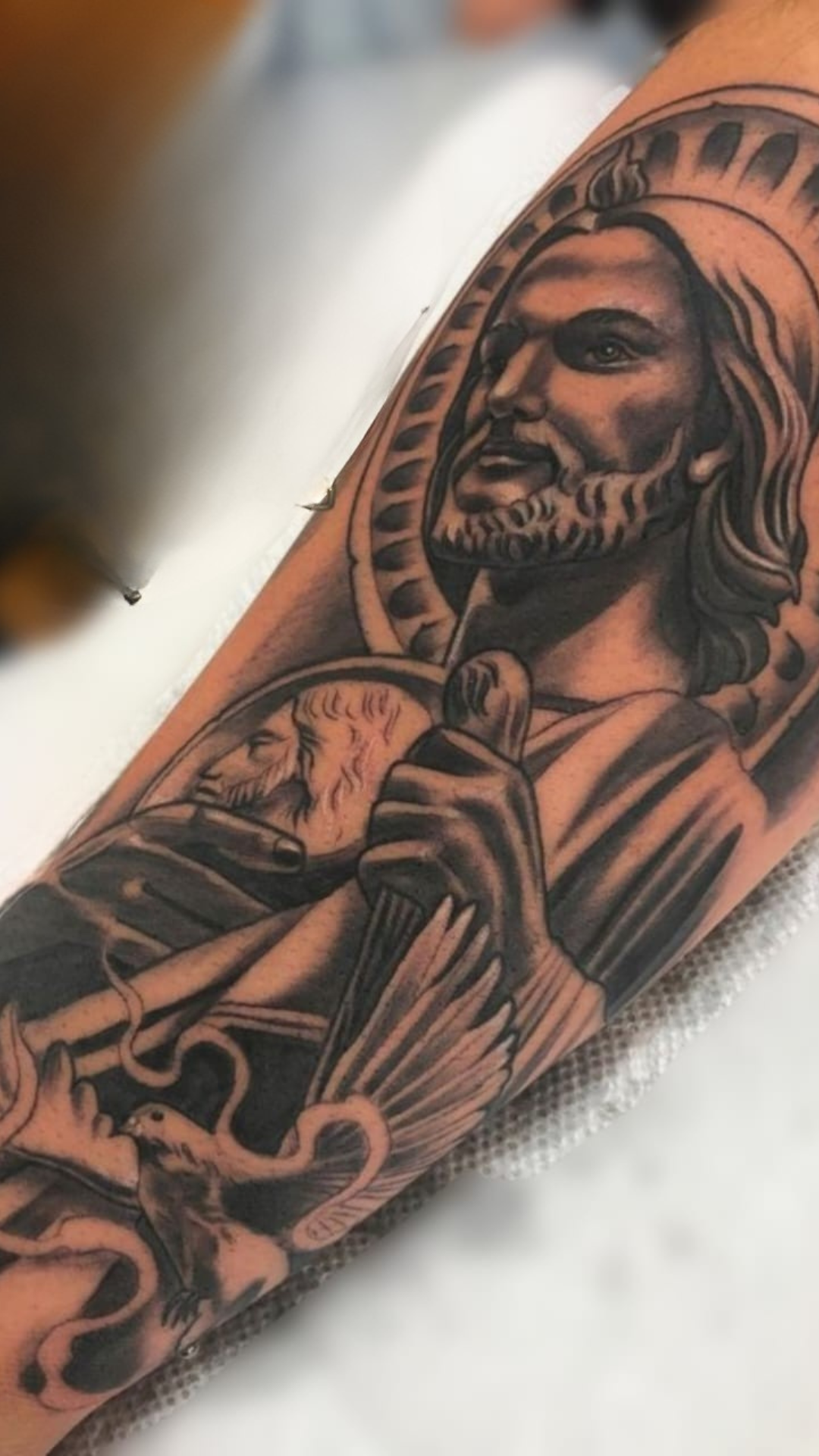 Black and grey religious portrait sleeve on forearm