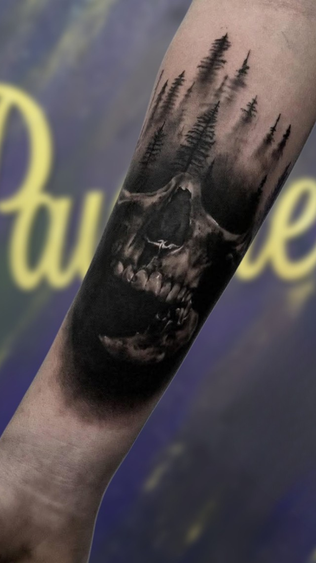Skull with pine forest tattoo on calf