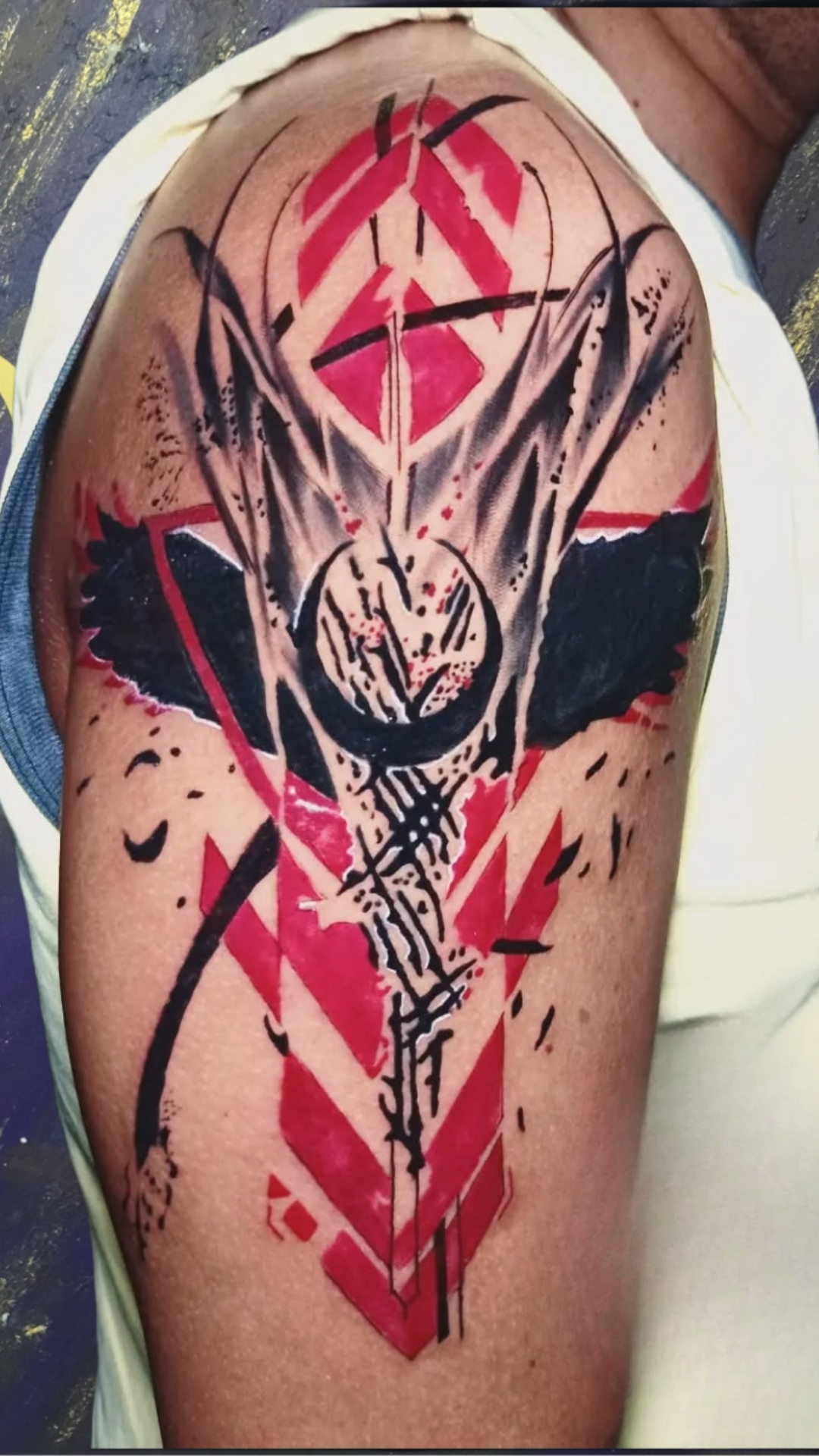 Abstract black and red tattoo on shoulder